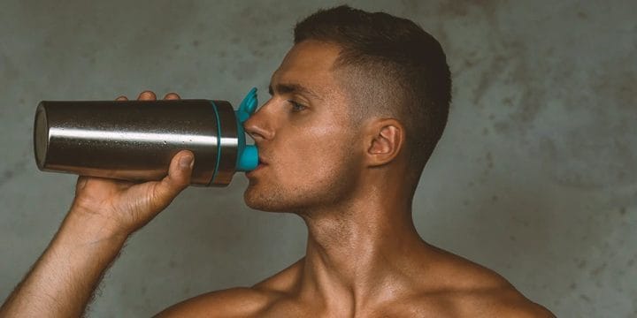 A buff male drinking pre-workout