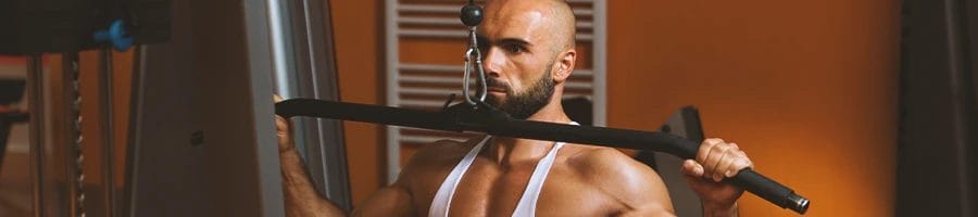 A balding buff male working out in the gym