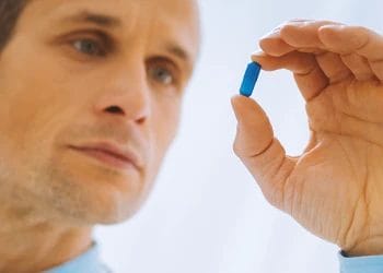 A person holding a blue pill