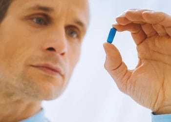 A person holding a blue pill
