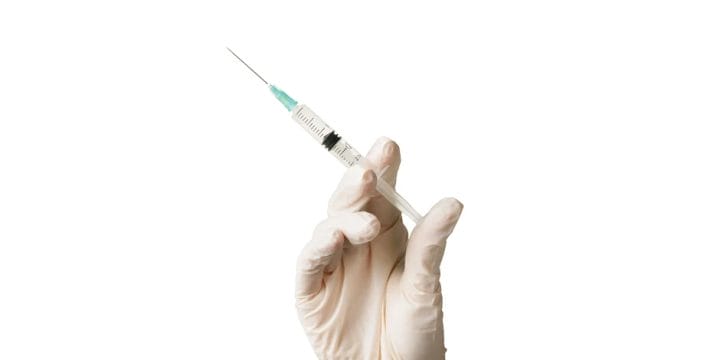 A health professional holding a syringe