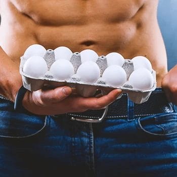Close up shot of a tray of eggs held by a muscular person