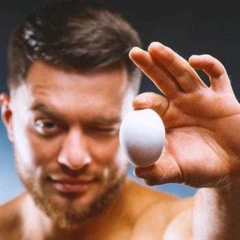 A person holding an egg to a camera