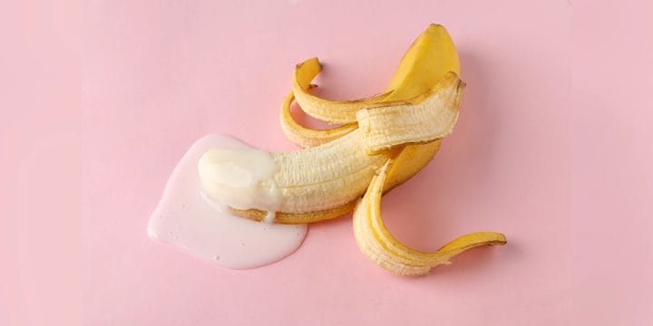 Erotic banana with white fluid in pink background, ejaculation concept