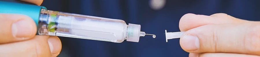 A person preparing a syringe of insulin