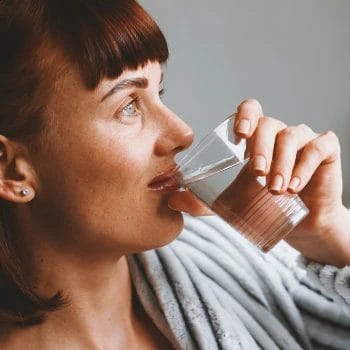 A woman drinking water in a glass