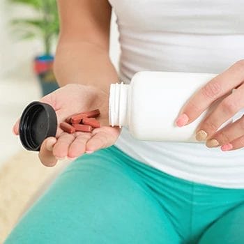 Pouring supplement capsules on hand