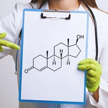 A doctor holding a clipboard showing the chemical diagram of testosterone