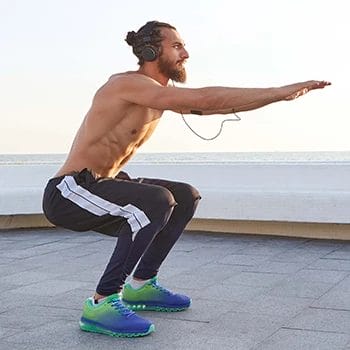 A man wearing a headset while performing squats