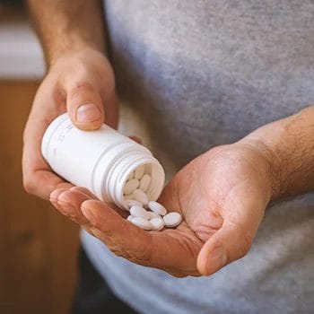 A person pouring nootropic pills from a pill bottle on their hands