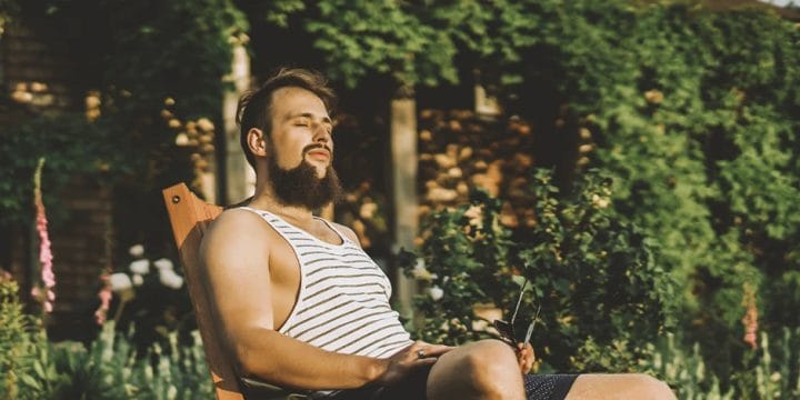 A hairy man sitting outside with a lot of testosterone