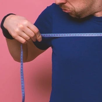 A man with low testosterone measuring his body fat