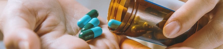 Close up shot of a person getting pills from a bottle