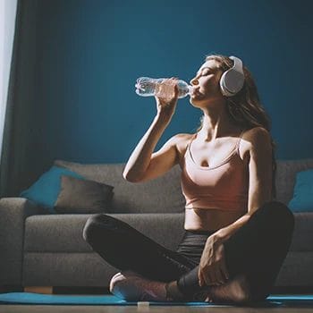 A woman doing yoga while drinking water