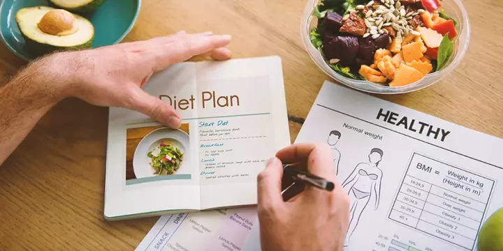 A person planning a diet plan to help burn fat