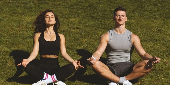 A couple doing yoga outside with nootropics