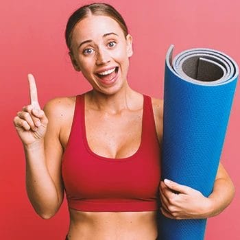 A woman holding gym flooring and smiling at the camera