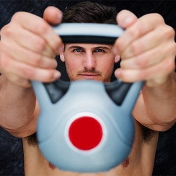 A man holding kettlebell at home