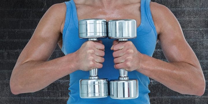 Holding two dumbbells with both hands, preparing for a dumbbell workout routine
