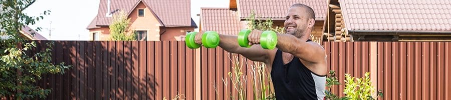 Using two dumbbells as an exercise outside his home