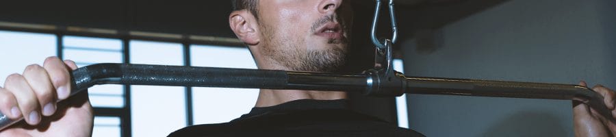 A man doing cable shoulder exercises in the gym