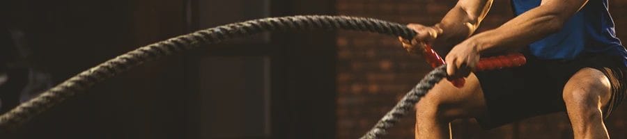 A person doing battle rope exercises in the gym