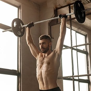 A man doing overhead press in gym