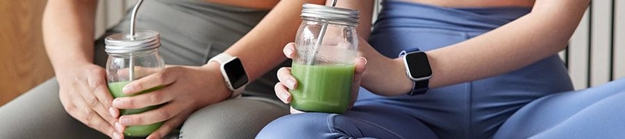 Holding healthy smoothie with gym partner