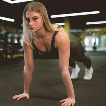 A woman doing EMOM workouts in the gym