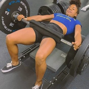A woman doing barbell hip thrusts in the gym