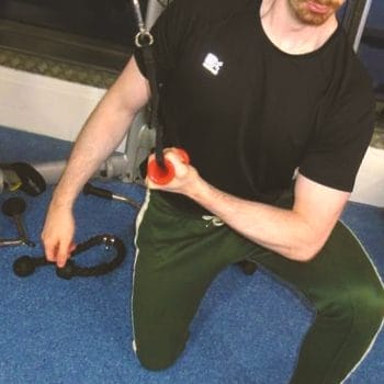 A person doing cable concentration extensions in the gym