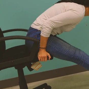 A woman doing a chair hamstring stretch