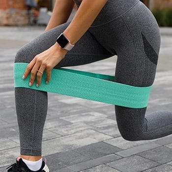A woman using resistance band for her knee