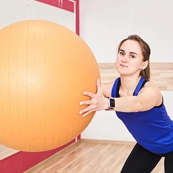 Woman holding on a medicine ball