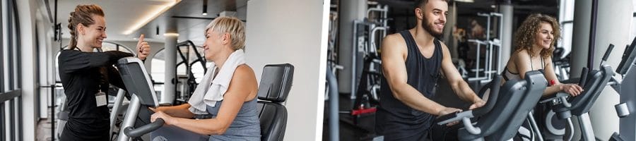 Woman with gym coach performing exercise on recumbent bike for her cardio