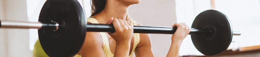 A woman is lifting and doing barbell exercises