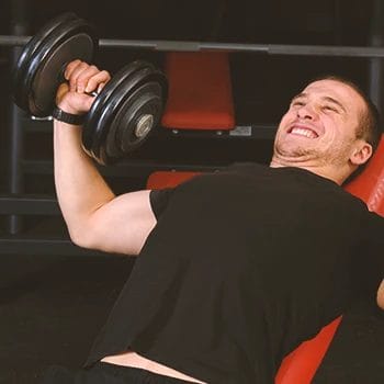 A person doing barbell presses on an incline