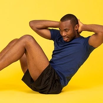 A guy doing crunches on a yellow background