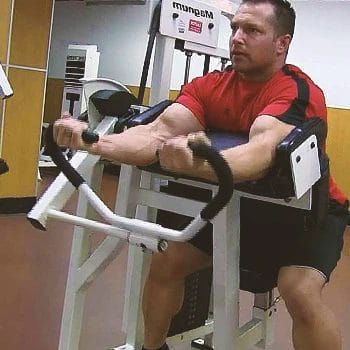 A buff male working out his biceps in the gym