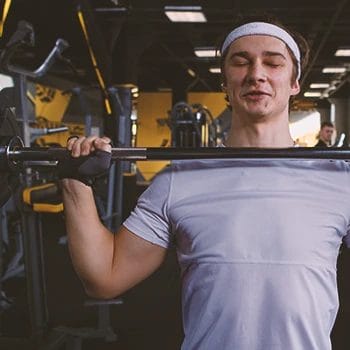 A person doing free weight workouts for his shoulders