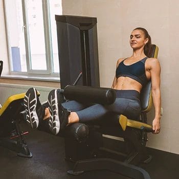 A woman in the gym doing leg extensions