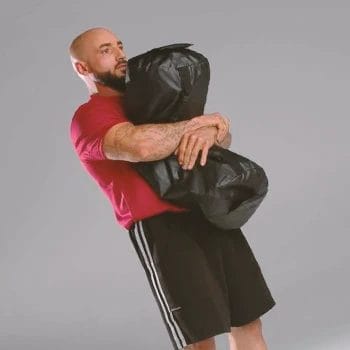 A person doing a sandbag bear hug squat