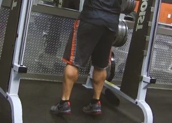 A man doing standing calf raises on a machine