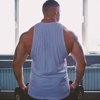 A buff man working out his back in the gym