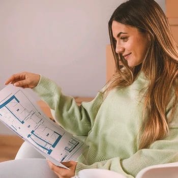 A woman checking a floor plan for a home gym