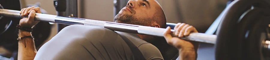 A person doing bench presses for upper muscle growth
