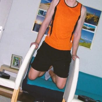 A person doing dips between chairs workout at home