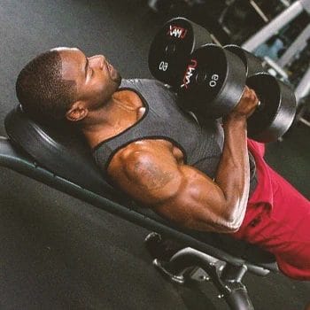 A person doing incline dumbbell squeeze press workouts in the gym