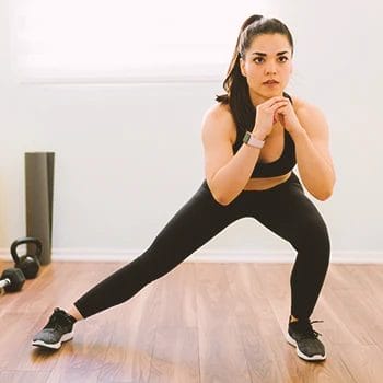 A woman working out with lateral lunges at home